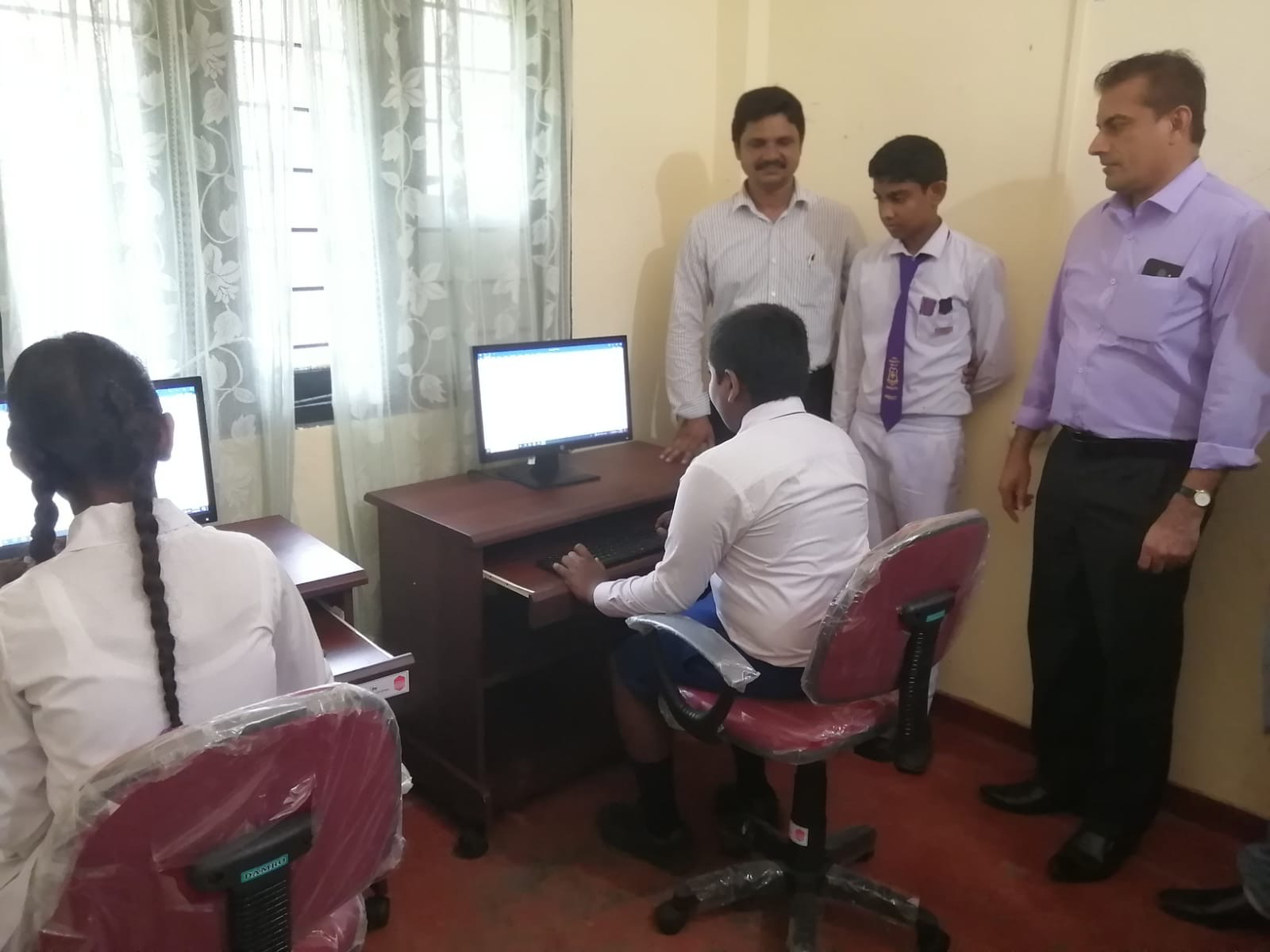 Children using desktop computers donated by Chemanex PLC