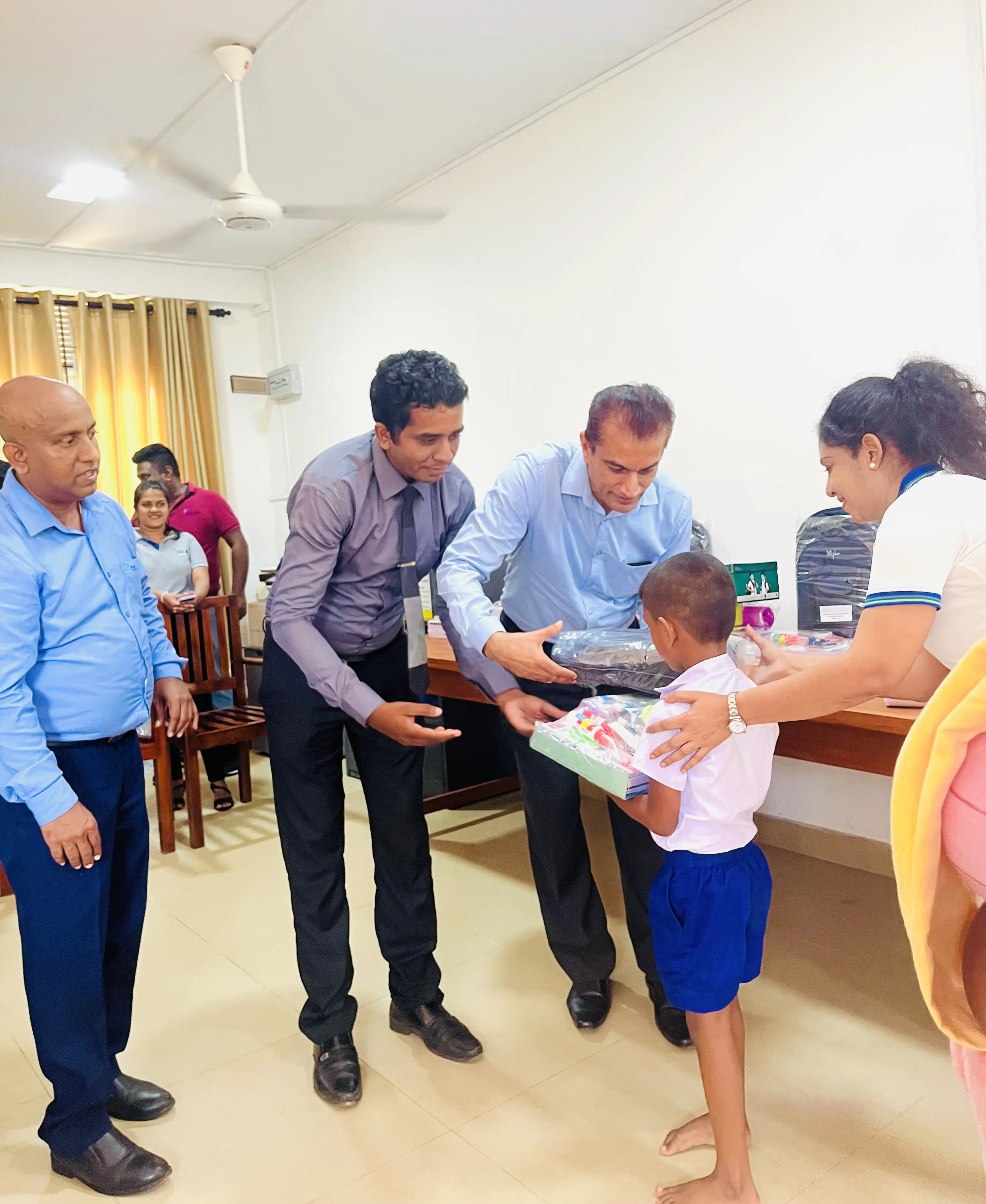 Two Chemanex PLC employees gifting school bags at a CSR event conducted by Chemanex PLC